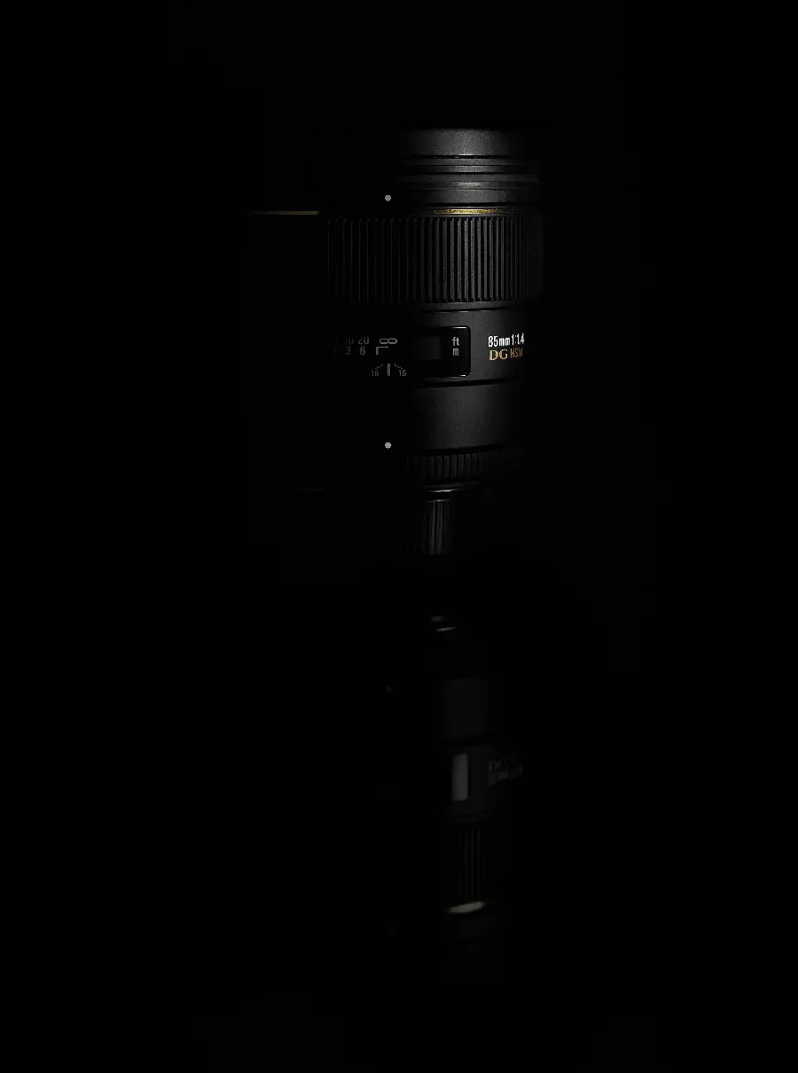 عکس لنز دوربین DSLR سیاه روی سطح بازتابنده