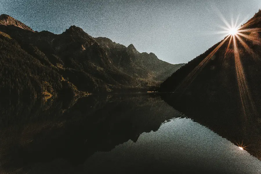 تصویر کوهستان و انعکاس آن در آب هنگام طلوع آفتاب با کیفیت 4K