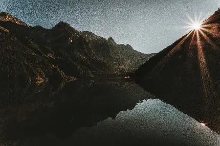 تصویر کوهستان و انعکاس آن در آب هنگام طلوع آفتاب با کیفیت 4K