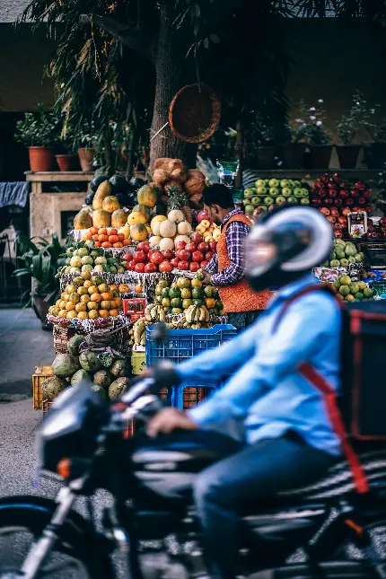 عکس موتورسوار در حال گذر از کنار غرفه خیابانی