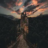 عکس قلعه تاریخی در آلمان با جنگل و آسمان ابری