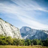 تصویر کوهستان با درختان و آسمان آبی برای والپیپر موبایل