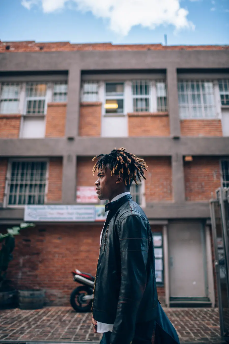 چاپ پوستر خرید تابلو مرد در حال قدم زدن کنار ساختمان آجری