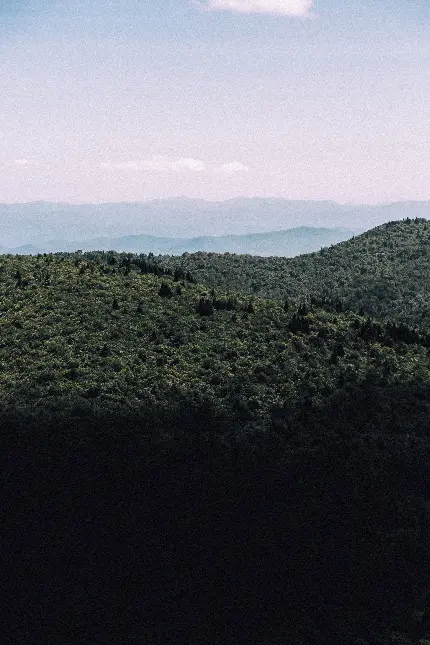 تصویر منظره کوهستانی با آسمان آبی و جنگل با کیفیت 4K