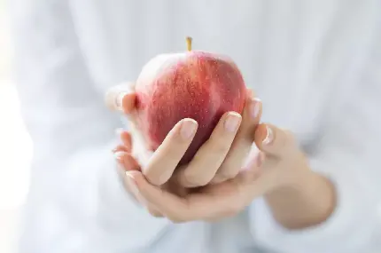 بک گراند با کیفیت سیب سرخ زیبا در دست با کیفیت فوق العاده