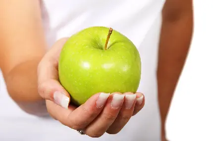 تصویر اچ دی سیب سبز براق و درخشان در دست زیبای یک دختر
