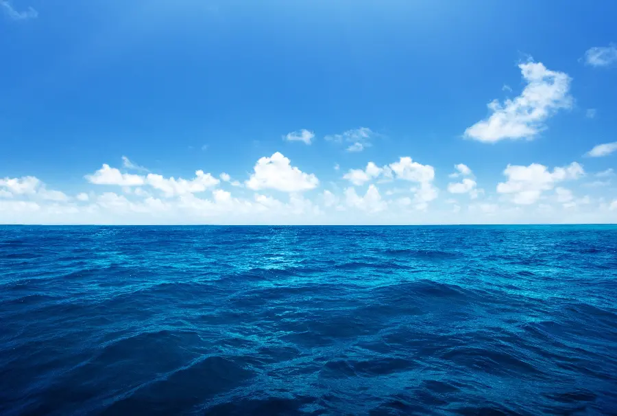 عکس اقیانوس واقعی در هوای آفتابی با موج های کوتاه و ابر های کوچک