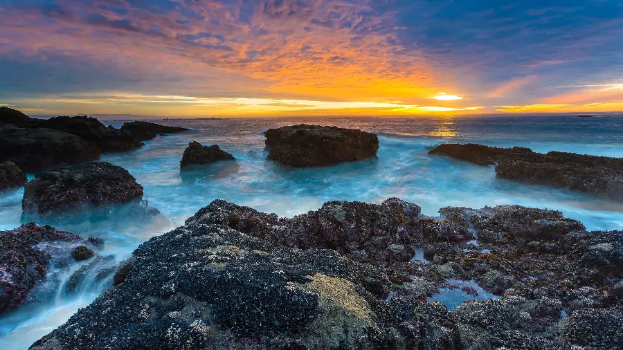 بهترین عکس غروب اقیانوس آبی در کنار صخره های کوچک و بزرگ 1401