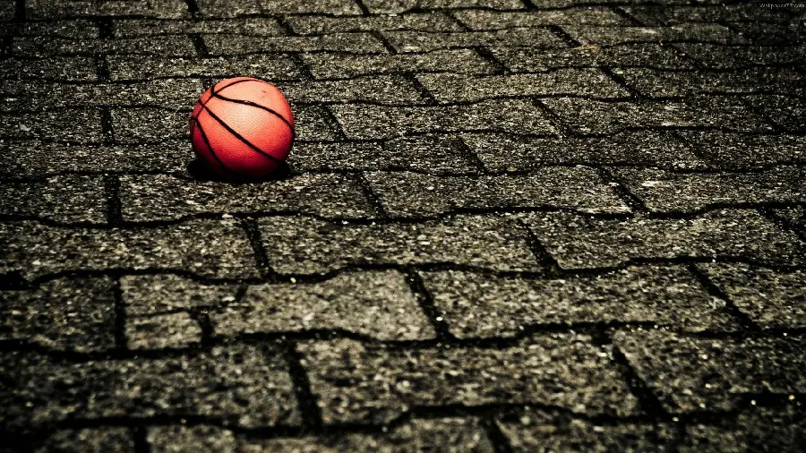 پس زمینه توپ مخصوص بازی بسکتبال بر روی سنگ فرش خیابان