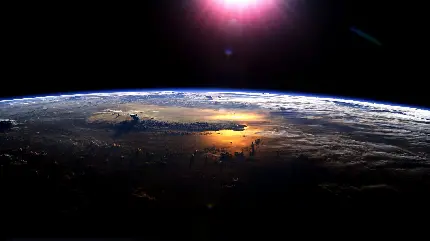 عکس زمینه ی واقعی و تک از برخورد نوری صورتی به سطح کره زمین از ناسا در ابتدای روز