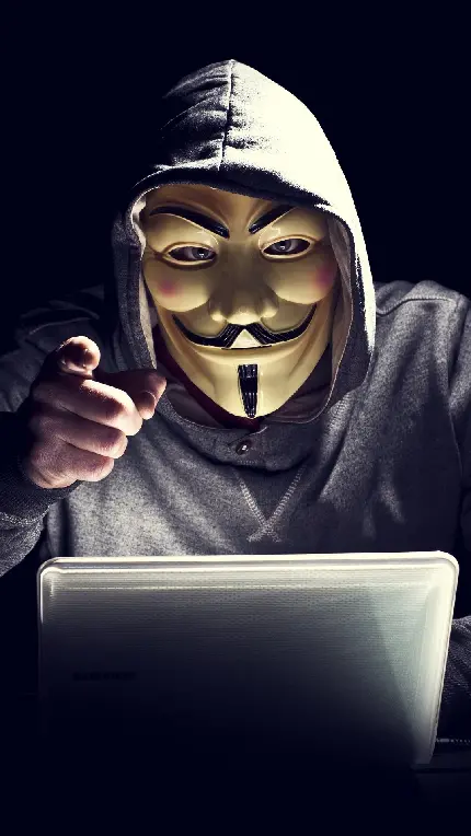 عکس هکر با ماسک دالی پشت لپ تاپ در حال هک کردن