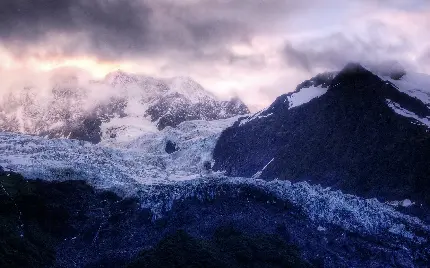 تصویر برف و کوهستان با ابرهای سیاه و تیره در آسمان