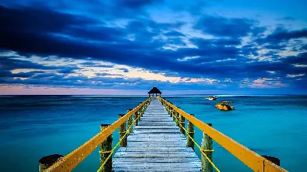 تصویر پل زرد چوبی بسیار زیبا بر بالای اقیانوس خارق العاده آبی رنگ با کیفیت HD