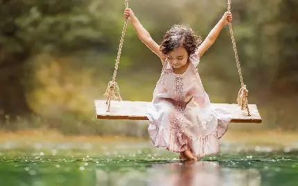 تصویر دختر کوچولوی خوشگل و بامزه در حال تاب بازی در دریاچه