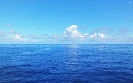 دانلود والپیپر شیک اقیانوس آبی زیر آسمان ابری و خوشرنگ برای ویندوز 11