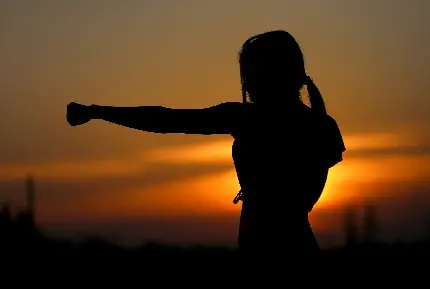 عکس تمرین کردن دختر به سبک کاراته ژاپنی و تنها در تاریکی برای والپیپر ویندوز 11