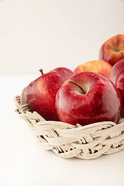 بک گراند زیبا از سبد پر از سیب قرمز خوشمزه و براق با کیفیت خوب