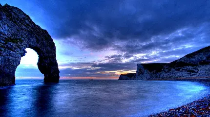 محبوب ترین بک گراند کامپیوتر با نقش اقیانوس آبی در فضایی تیره در کنار صخره های زیبا با کیفیت اصلی