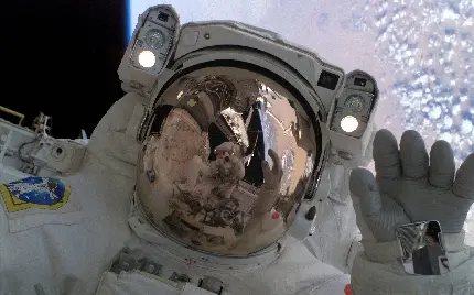 عکس فضانورد ناسا در حال سلام کردن بر روی جو کره زمین