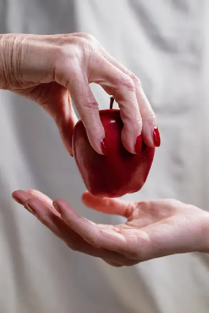 سیب قرمز خوش رنگ در دست با عکاسی بی نظیر و با کیفیت 