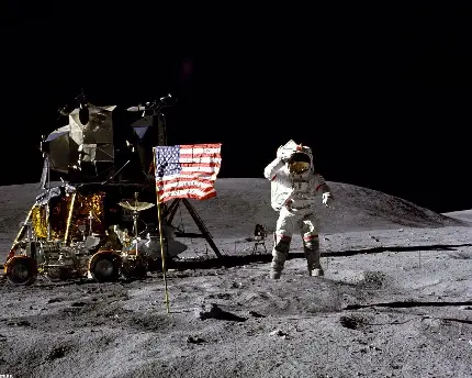 عکس لحظه فرود آمدن فضانورد ناسا بر روی کره ماه در کنار سفینه فضایی و پرچم آمریکا