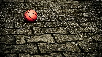 پس زمینه توپ مخصوص بازی بسکتبال بر روی سنگ فرش خیابان