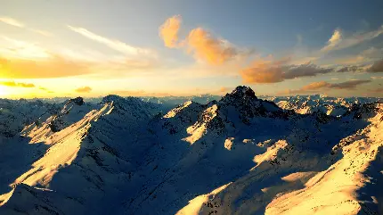 زیباترین عکس طلوع و غروب عاشقانه خورشید در کوهستان پوشیده از برف و آسمان ابری