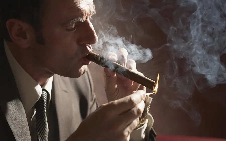 مرد جذاب و با ابهت در حال کشیدن سیگار در یک نمای خاص و هنری 