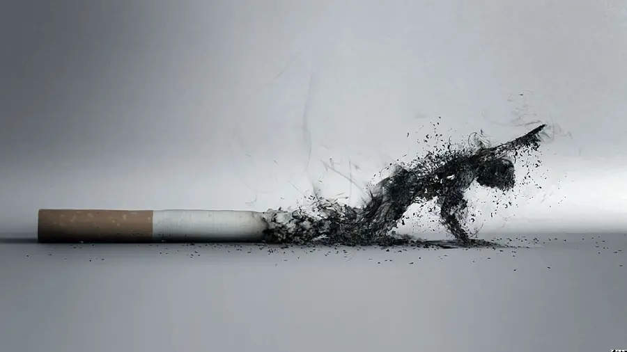 دانلود عکس خلاقانە از انسان مشکی رنگ ناتوان بە زمین افتادە حاصل از دود سیگار در زمینە خاکستری رنگ