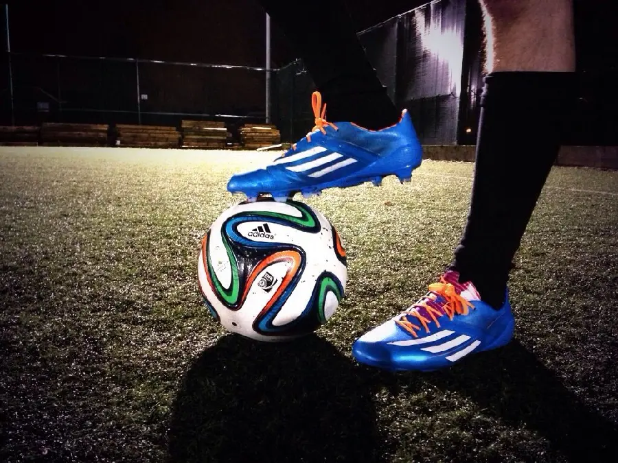 نمای خاص از بازی با توپ با کفش فوتبال آبی رنگ با کیفیت عالی HD