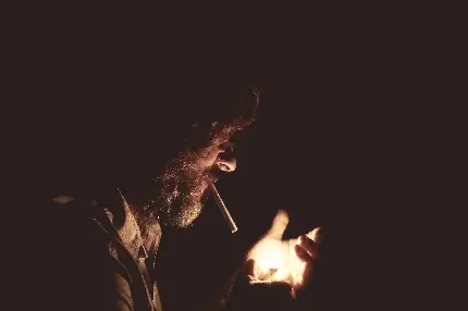دانلود تصویر استوک از مرد درماندە ریش و سبیل‌ دار در وضعیت روشن کردن فندک برای دود سیگار