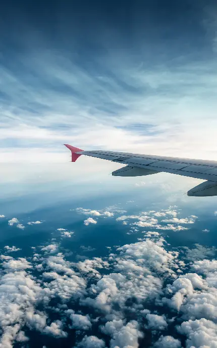 عکس با کیفیت از آسمان آبی و ابری در بالای هواپیما مخصوص زمینه