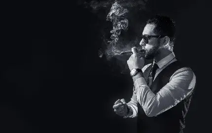 عکس استوک مجلل از مرد جنتلمن عینک زدە در حال دود کردن سیگار