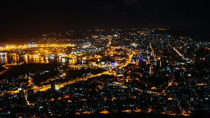 دانلود عکس با ٱبهت از شهری با روزنە‌های نور در آن در شب تاریک