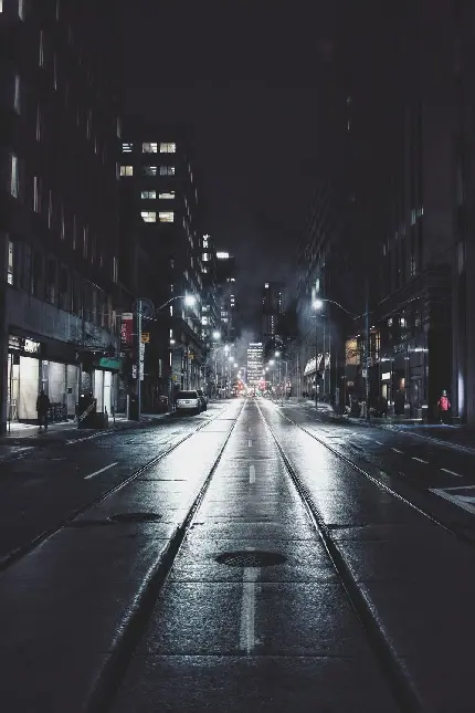 عکس استوک براق و نورانی از کف جاده شهری مشکی رنگ در شب تاریک