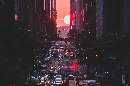 تصویر پر هیاهو و نورانی از جاده شهری و جابەجایی اتومبیل‌ها در آن در هنگام غروب خورشید