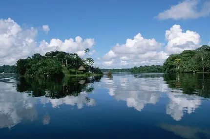 عکس استوک ناز از انعکاس ابرهای آسمان در آب رودخانه آمازون و تودەی سبز و کلبە کوچک