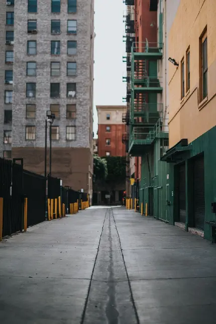 عکس پروفایل خاص واتساپ از جاده شهری خاکستری رنگ بن بست و در حصار ساختمان‌های بلند و پلکان‌های اضطراری سبز رنگ
