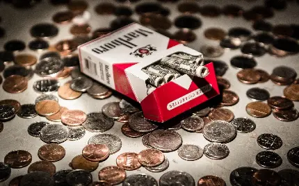 تصویر زمینه جعبه سیگار مارلبرو با پول کاغذی داخل و سکه اطراف آن