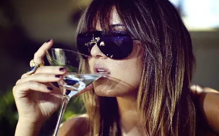 تصویر فوق العاده جذاب از دختر خاص با عینک آفتابی در حال نوشیدن 