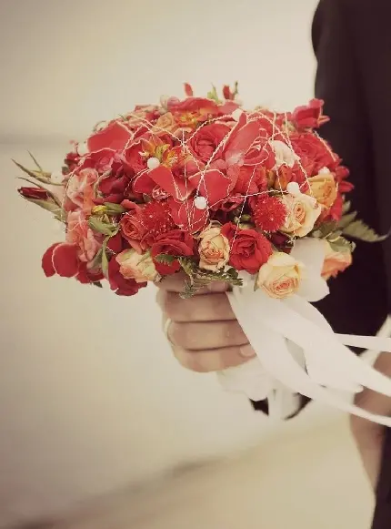 پوستر جالب توجە از دستە گلی در دستان داماد برای عروس