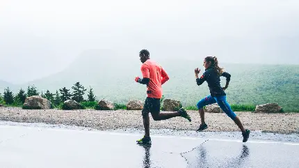 نمای زیبا و باکیفیت از دویدن زن و مرد در کنار هم در هوای بارانی 