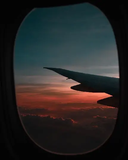 والپیپر جذاب از آسمان و غروب خورشید در پنجره هواپیما