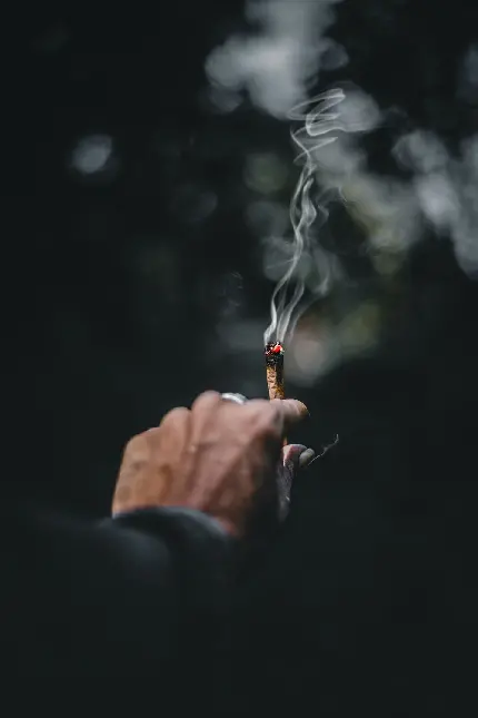 تصویر استوک اندوهناک از دست پیر در حال دود کردن سیگار
