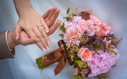 دانلود عکس زمینە رمانتیک از دستە گل زیبا و دست‌ تو دست عروس و داماد