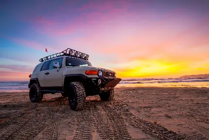 دانلود عکس ماشین تویوتا در ساحل هنگام غروب خورشید