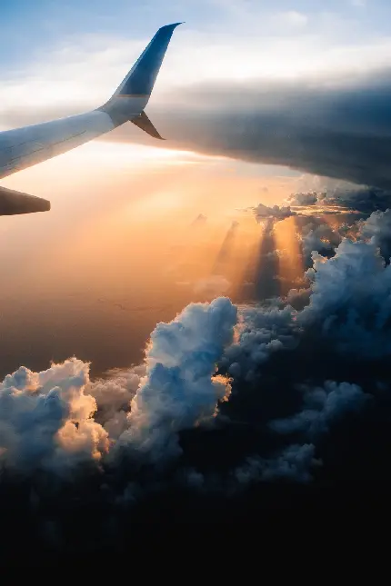 تصویری زیبا از بیرون پنجره هواپیما در آسمان و غروب خورشید