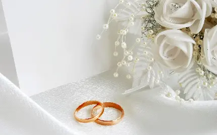 بک گراند جمیل از دستە گل سفید عروس و حلقە‌های ازدواج