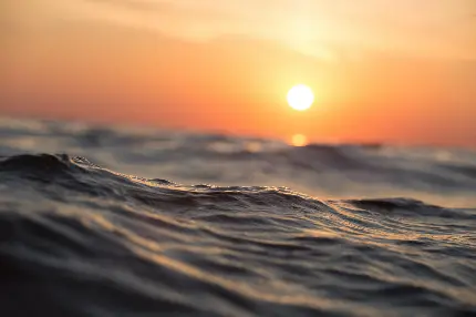والپیپر غروب خورشید در آسمان نارنجی و امواج دلنشین دریا