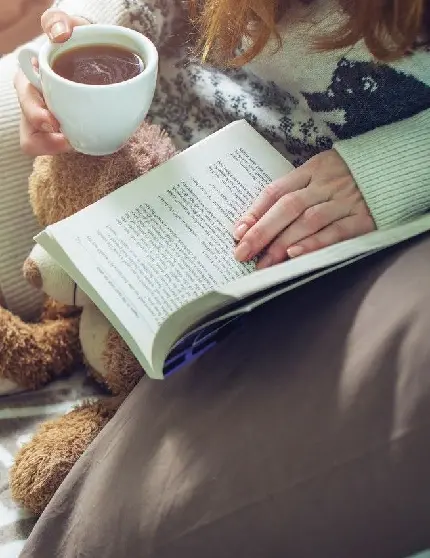 تصویر هنری از دختر در حال خواندن کتاب و نوشیدن چای 